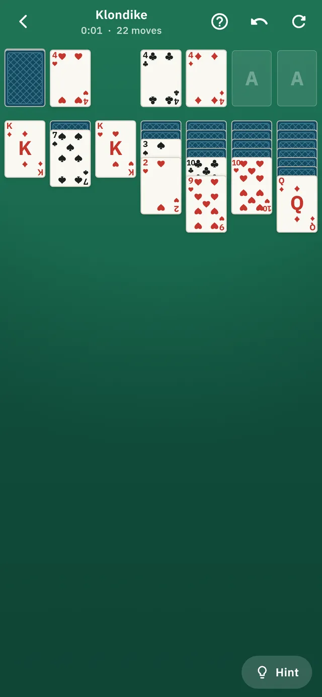 A game of Klondike solitaire in progress on a green felt table.